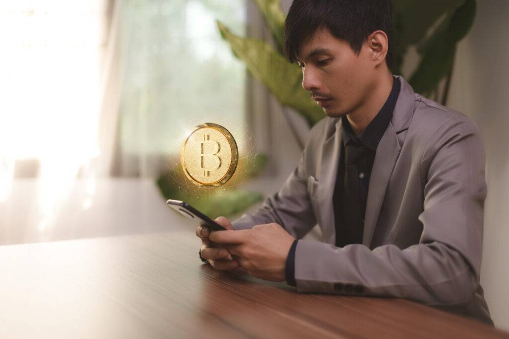 Man in suit using phone with Bitcoin graphic overlay, representing foreign financial service providers.